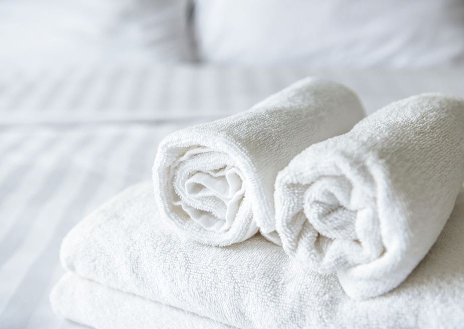 Freshly,laundered,fluffy,towels,on,bed,in,hotel